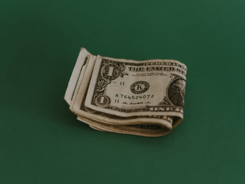 Dollar bill folded in half on a green background